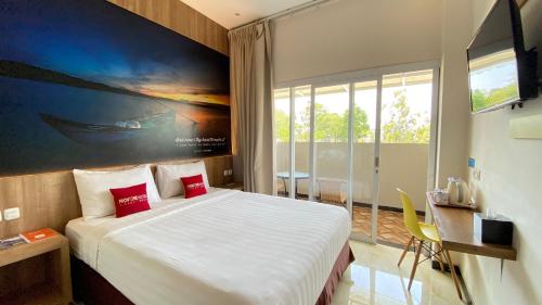 Un dormitorio con una cama con un cuadro en la pared. en Front One Hotel Airport Solo, en Solo