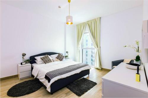 ein weißes Schlafzimmer mit einem Bett und einem Fenster in der Unterkunft Lovely Waterfront Private 2BR Apartment Yas Island in Abu Dhabi