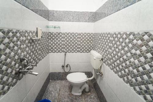 a bathroom with a toilet and tiled walls at RK appartment 3 bedroom with kitchen and balcony in Varanasi