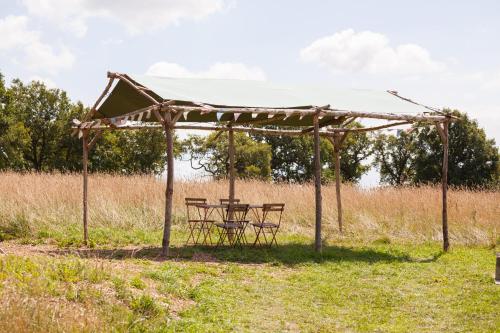 a picnic table under a canopy in a field at Barbara Shepherds Hut in Kent