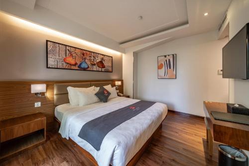 a hotel room with a large bed and a desk at Edoya Hotel Ben Thanh in Ho Chi Minh City