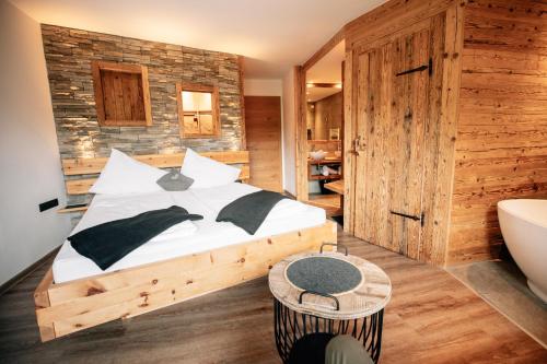 a bedroom with a bed and a tub in a room at Hotel Sonnberg in Saalbach Hinterglemm