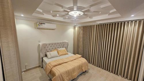 a bedroom with a bed and a ceiling at شقق قاردينيا in Aş Şafā