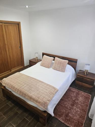 a bedroom with a large bed with white sheets and pillows at Casa da estrela canopus in Cabeço Chão
