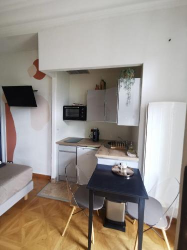 - une petite cuisine avec une table bleue dans une chambre dans l'établissement Le Splendide Cosy Room, à Aix-les-Bains