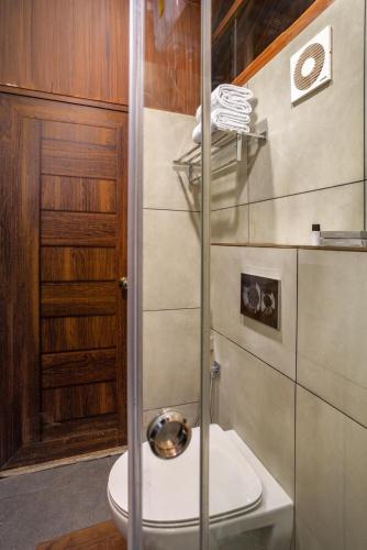 a bathroom with a toilet and a glass shower at Eterno Camellia & Elettaria Resort with Pool in Munnar