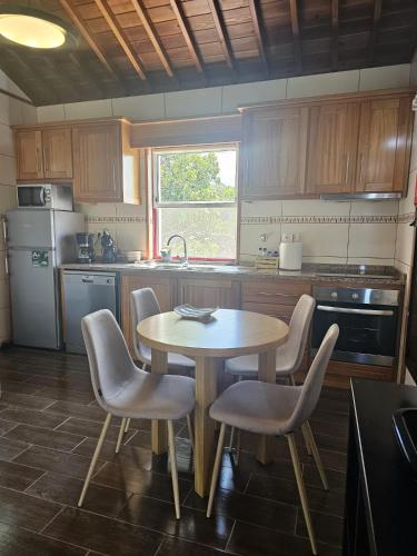 a kitchen with a table and chairs and a sink at Casa da estrela canopus in Cabeço Chão