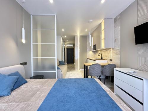 a bedroom with a large bed and a kitchen at Сучасні апартаменти в новобудові in Lviv
