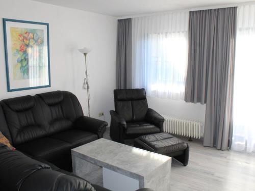un salon avec un canapé et deux chaises dans l'établissement Ferienhaus Nr 35, Kategorie Komfort L, behindertenfreundlich, Feriendorf Hochbergle, Allgäu, à Bichel