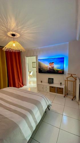 une chambre avec un lit et une télévision à écran plat dans l'établissement Appartement rénové 76m2 proche plage, à La Rudelière