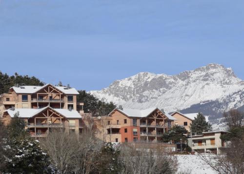 a group of houses in front of a mountain at L'Ecrin du Lac in Chorges
