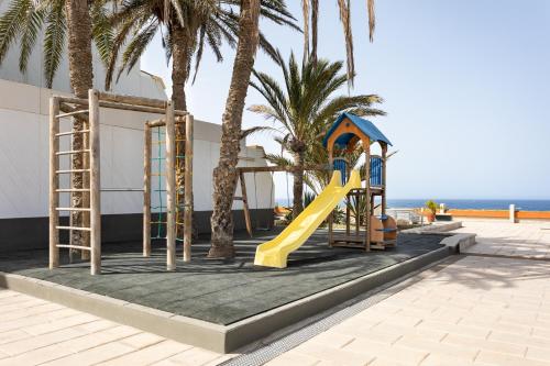 a playground with a slide and palm trees on the beach at Listen the TIDE -201 A in Costa Del Silencio