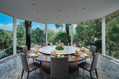 a dining room with a table and chairs and large windows at Crowne Plaza Suzhou by IHG in Suzhou