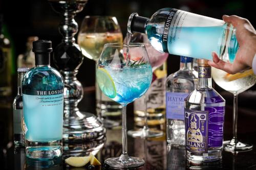 a person pouring a blue drink into a martini glass at Crowne Plaza Suzhou by IHG in Suzhou