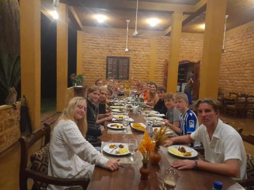a group of people sitting at a long table at Happy Man Village in Bentota