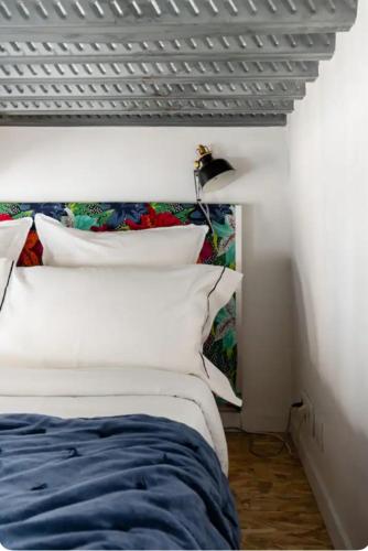 une chambre avec un lit avec des oreillers blancs dans l'établissement Maison Pépouze, à Marseille