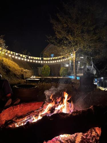 a fire pit at night with lights in a yard at Himkosi Farm by the River in Almora