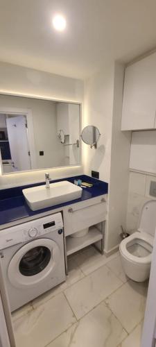 a bathroom with a sink and a washing machine at Orbi City Apartment Block A in Angisa