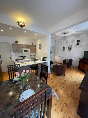 une cuisine et un salon avec une table et des chaises dans l'établissement LE SAINT JULIEN 3étoiles - Hypercentre - Proche Thermes - Balcon, à Vichy
