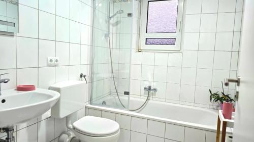 un bagno bianco con un water e un lavandino di HAPPY HOMES PINK - Up to 5 - Küche - W-LAN - Netflix - Honig - Badewanne a Nidda