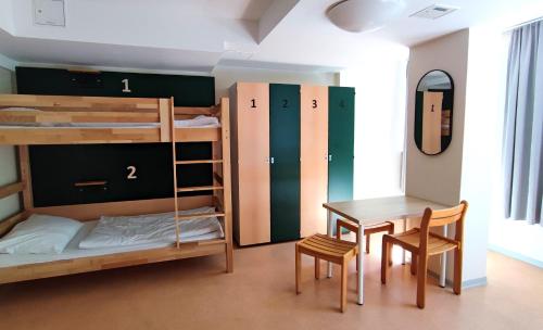 a room with bunk beds and a table and chair at martas Gästehäuser Hauptbahnhof Berlin in Berlin