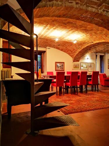 a dining room with a table and red chairs at CASA DEL CANTA in Borgomale