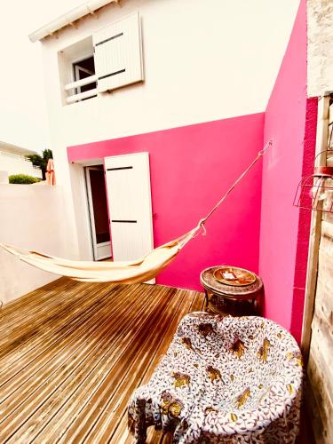 - un hamac dans une chambre avec un mur rose dans l'établissement Maison de plage à 100m de la mer, à Talmont-Saint-Hilaire