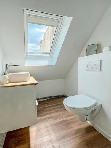 une salle de bain avec des toilettes blanches et une fenêtre dans l'établissement COPENHAGUE- Cathédrale, Maison du XVI siècle, à Reims