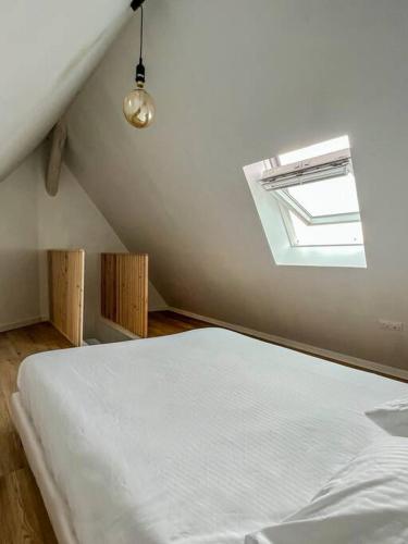une chambre avec un lit blanc et une fenêtre dans l'établissement COPENHAGUE- Cathédrale, Maison du XVI siècle, à Reims