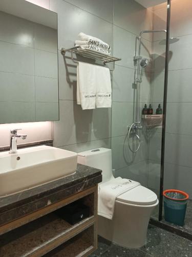 a bathroom with a sink and a toilet and a shower at Fan's Hotel Palo in Tacloban