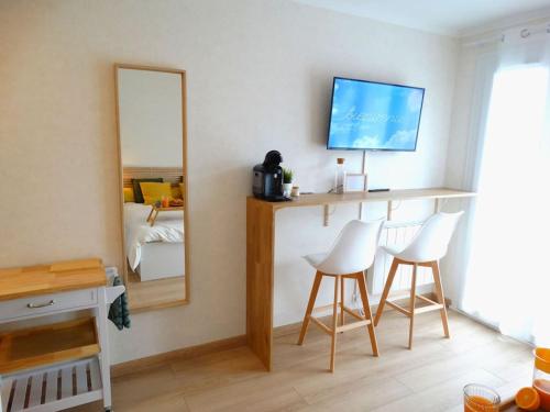 a room with a mirror and two chairs and a bed at Comme à l'hôtel in Aurillac