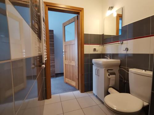 a bathroom with a toilet and a glass door at Złota 24 in Karwia
