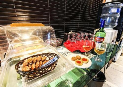 a table with food and drinks and a bottle of wine at Nostalgia Hotel in Paju