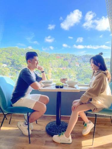 a man and a woman sitting at a table at Gold View Boutique Hotel Đà Lạt in Da Lat