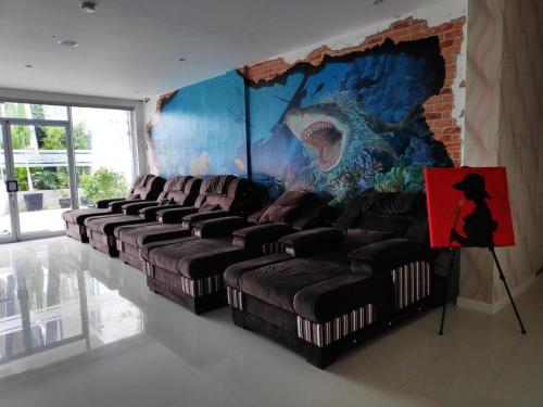 a row of leather couches in a room with a mural at The Hotel Sophia in Cauayan City
