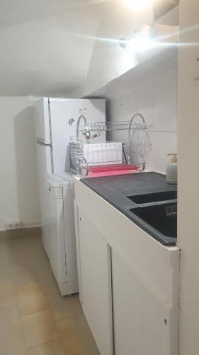 La cuisine est équipée d'un séchoir à vaisselle et d'un réfrigérateur. dans l'établissement Appartement cosy, à Courthézon