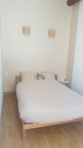 Ce lit se trouve dans un dortoir doté d'un matelas blanc. dans l'établissement Appartement cosy, à Courthézon
