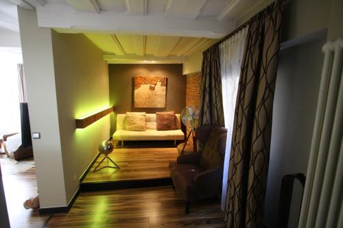 a living room with a couch and a chair in a room at Elements Hotel in Regensburg