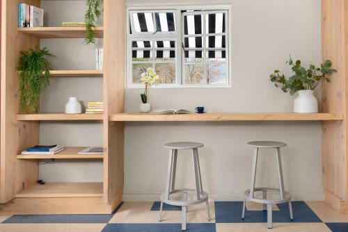 a desk with two stools in a room with a window at Neighbourgood Franschhoek in Franschhoek