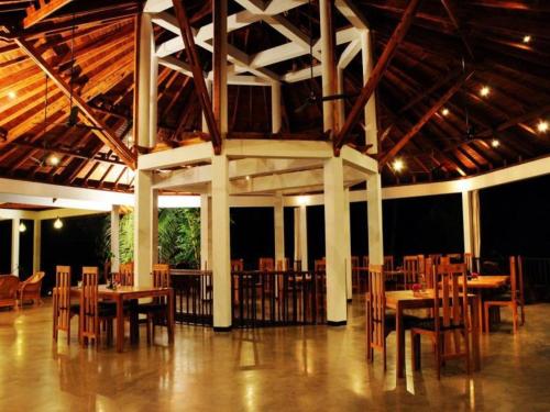 a dining room with tables and chairs in a building at Brook Boutique in Sigiriya
