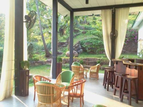 a patio with chairs and a bar with a view at Brook Boutique in Sigiriya