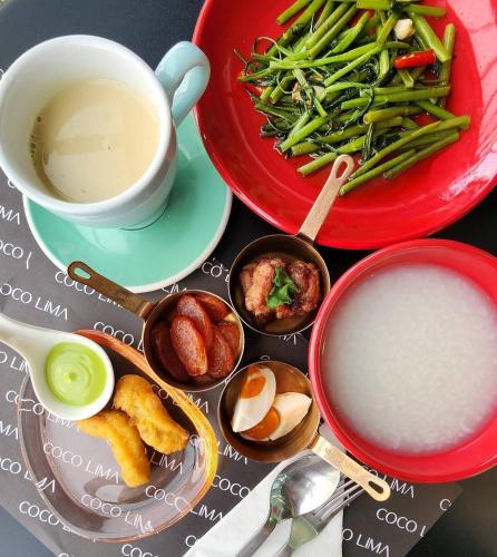 a table with two plates of food and a cup of coffee at Hotel Sapin in Pom Prap