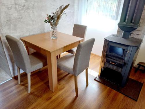 a dining room table with chairs and a wood stove at TARA Vila Rajak in Zaovine