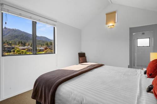 Un dormitorio blanco con una cama y una ventana grande. en *** LAKE VILLA 458 ***, en Hanmer Springs