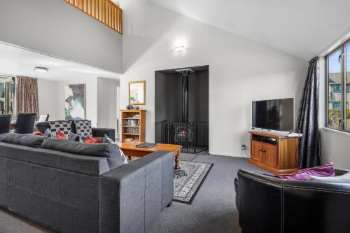 Una sala de estar con dos sofás y un televisor. en *** LAKE VILLA 458 ***, en Hanmer Springs