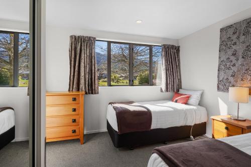 a bedroom with two beds and a window at *** LAKE VILLA 458 *** in Hanmer Springs