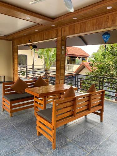 a patio with a wooden table and benches on a balcony at Tam Coc Westlake Homestay in Ninh Binh