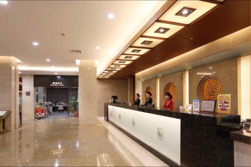 a lobby with people standing at a counter in a store at International Conference Hotel Nanjing in Nanjing
