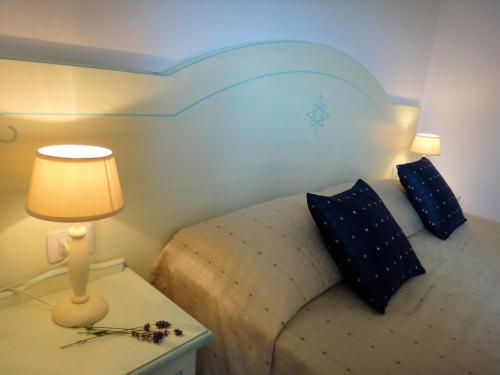 a bedroom with a bed and a table with a lamp at Sa Fiorida Appartamenti in Valledoria