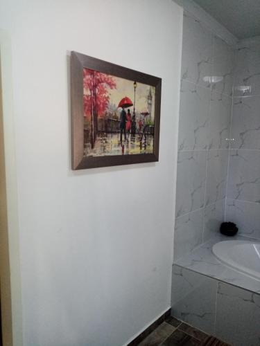a painting hanging on a wall in a bathroom at De la Rose Guesthouse in Lephalale